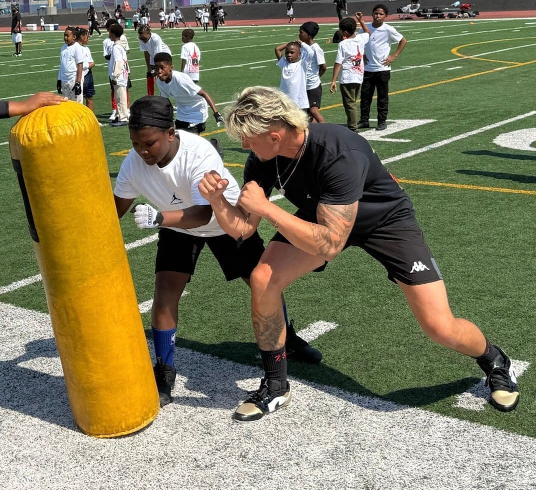 Coach guiding an athlete through a private tackle lesson